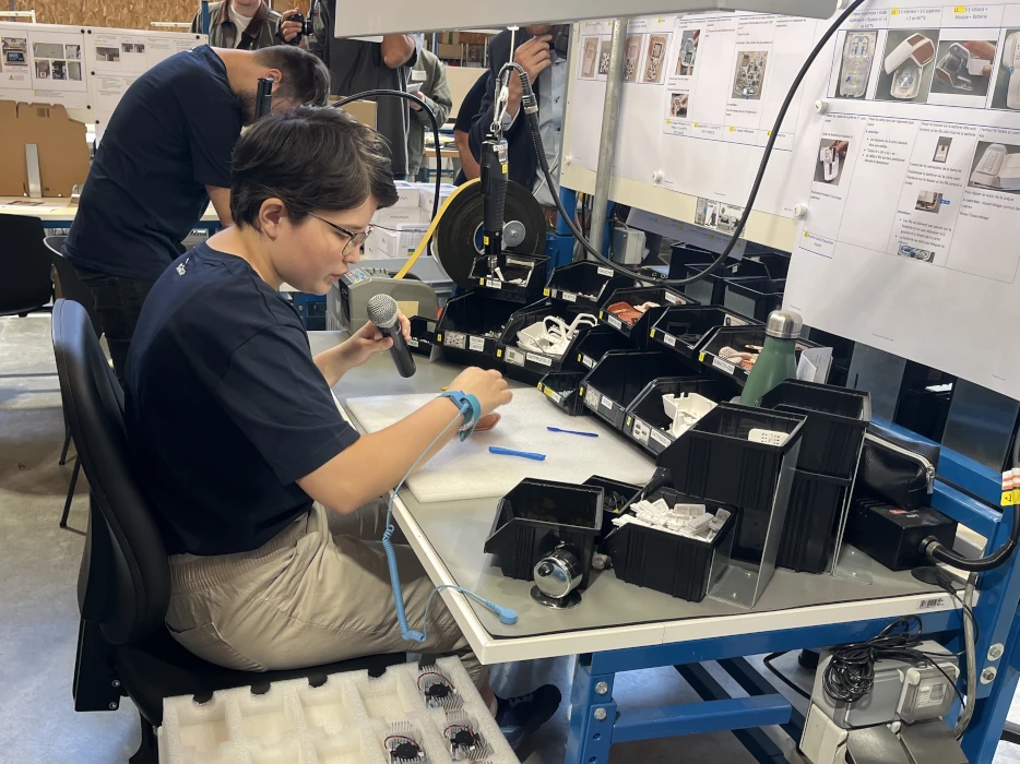 Opératrice AMIPI assemblant le dispositif HÉRA sur la ligne de production